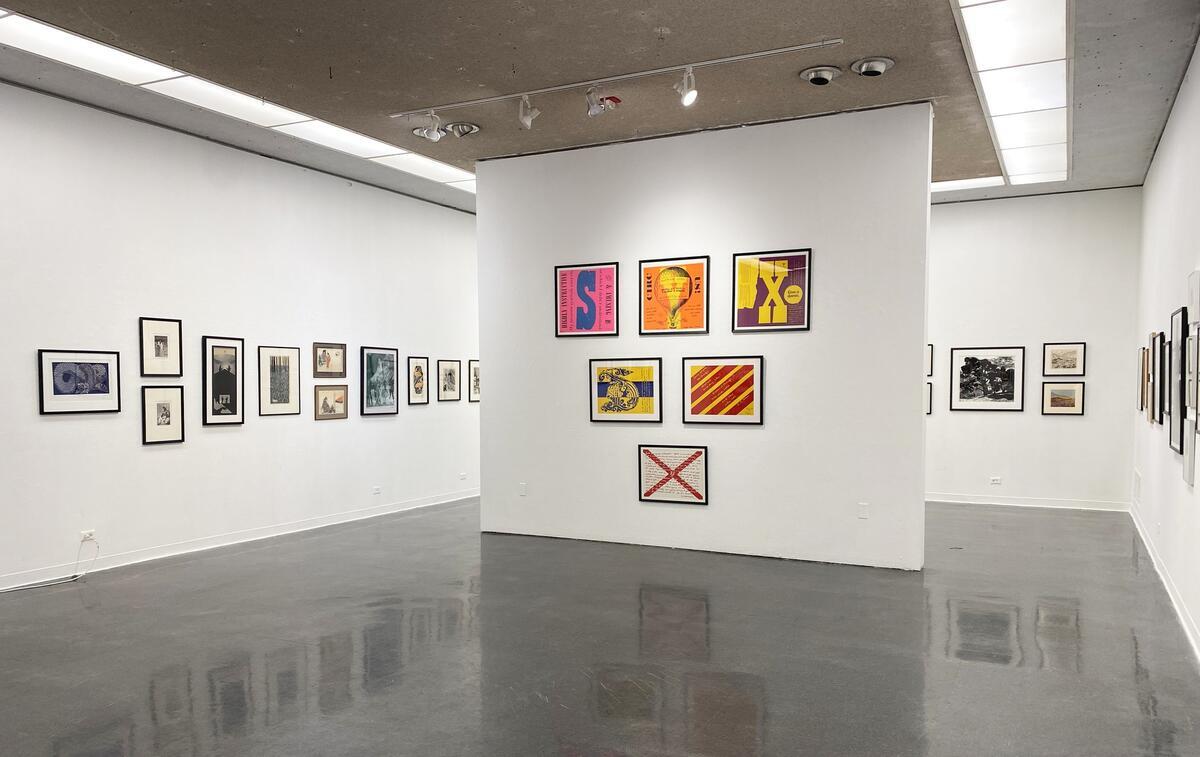Art gallery with framed 2 dimensional artworks on three walls